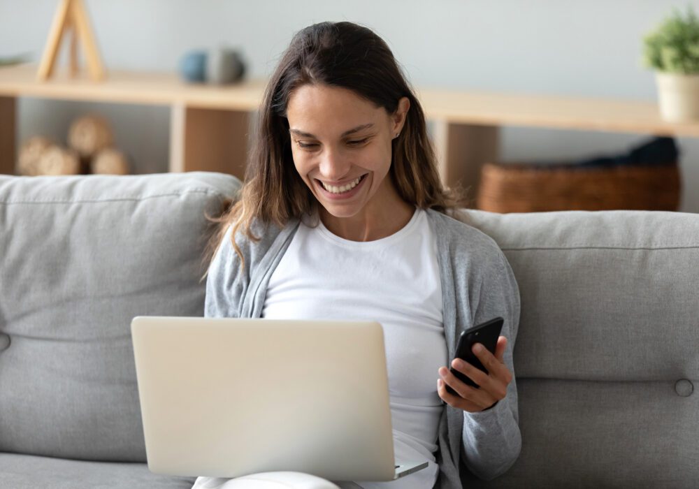 woman on couch researching selling a contract for deed on her laptop