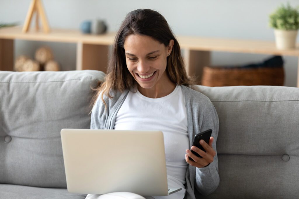 woman on couch researching selling a contract for deed on her laptop